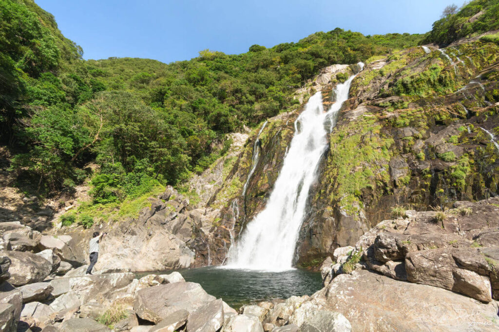 大川の滝を前にして写真を撮る観光客