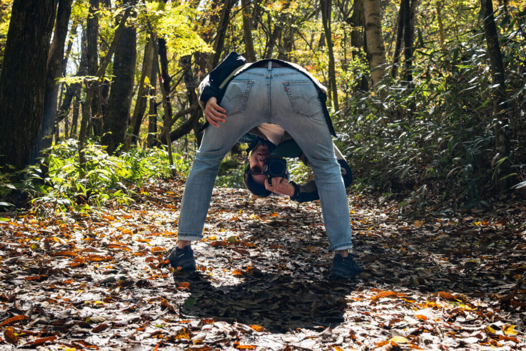 森の中で股の下からカメラを構える人