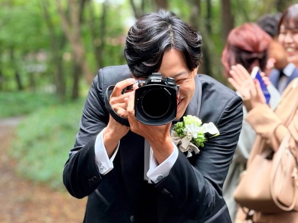 タキシード姿でカメラを構える人