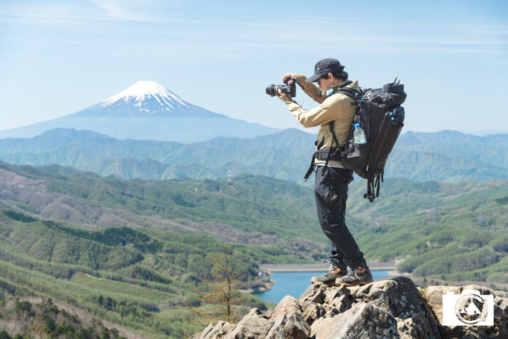 富士山を背景にカメラを構える男性