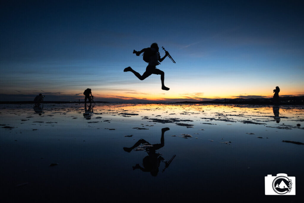 浅瀬の海面で飛び跳ねる男性