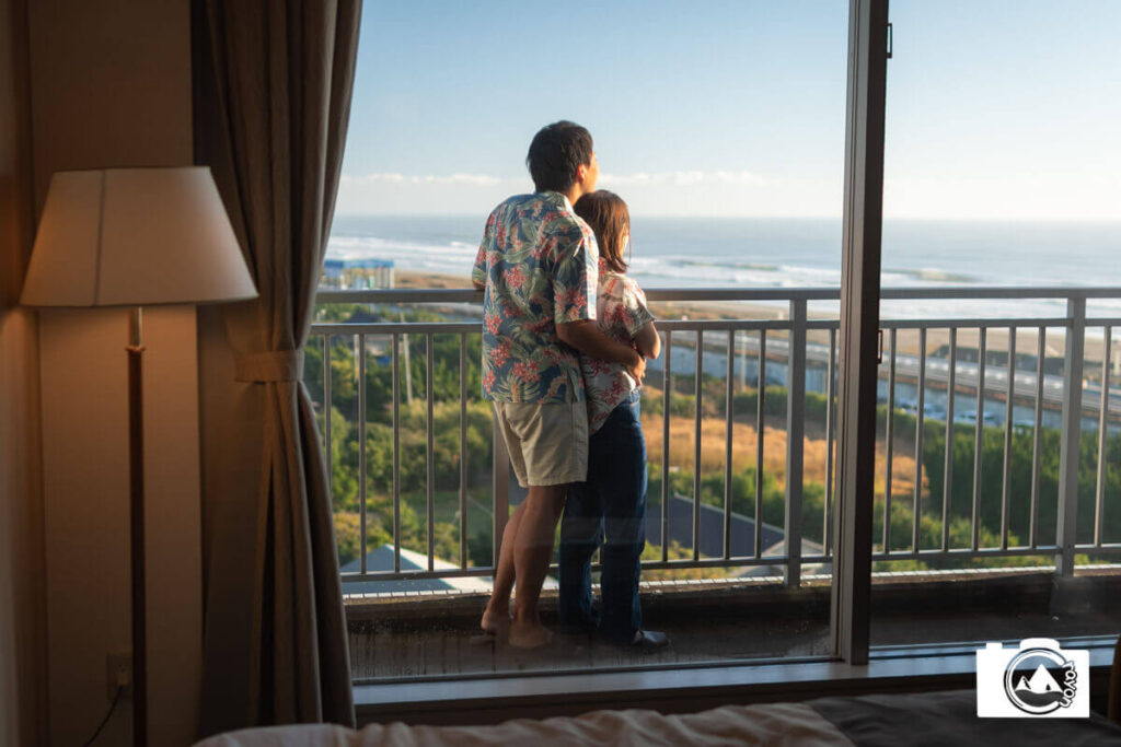 バルコニーから海を望むカップル