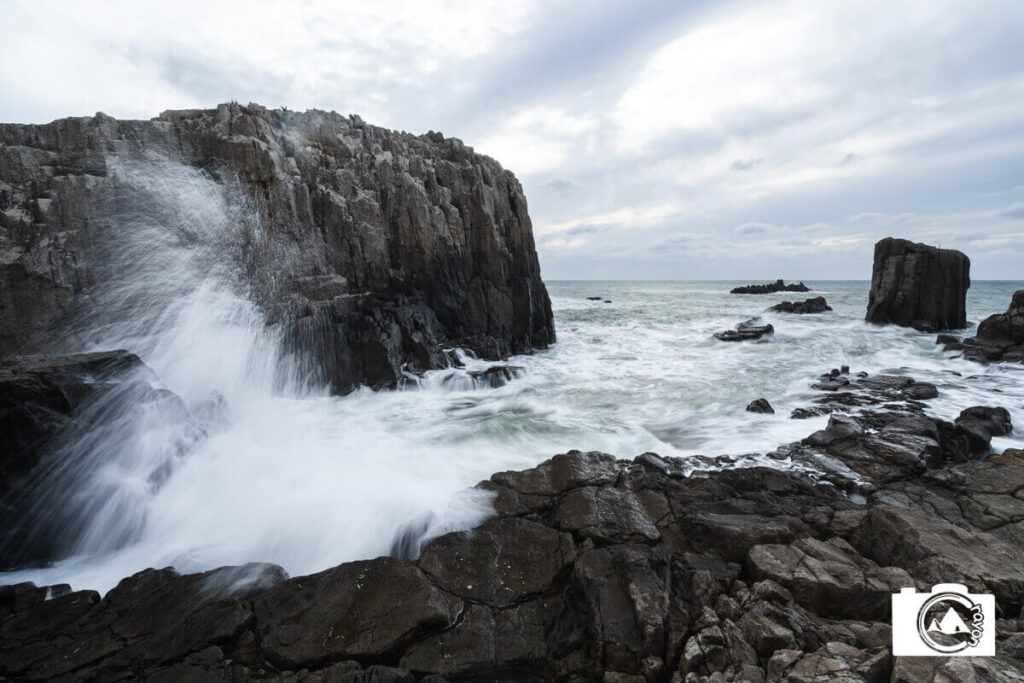 波飛沫が舞う岩の海岸