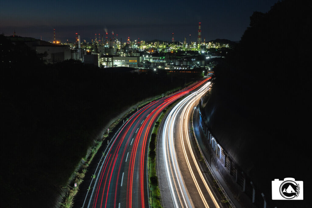 走行する車の軌跡と工場夜景