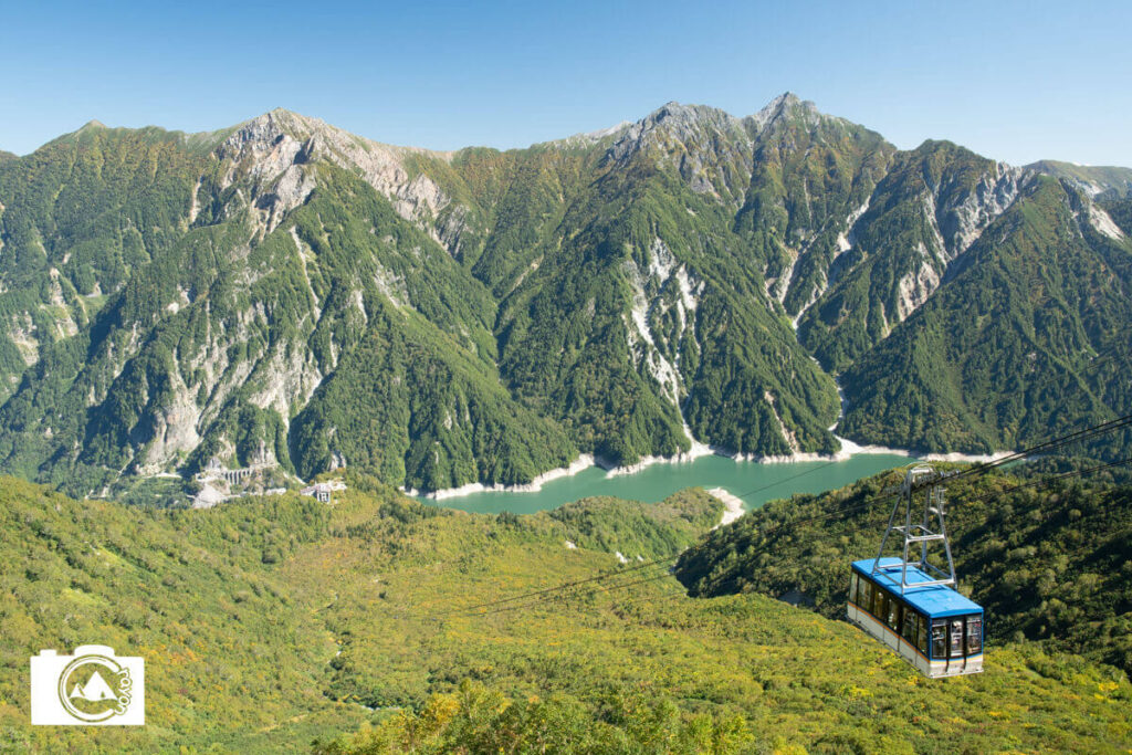 谷底から登ってくるロープウェイと背景に広がる山々