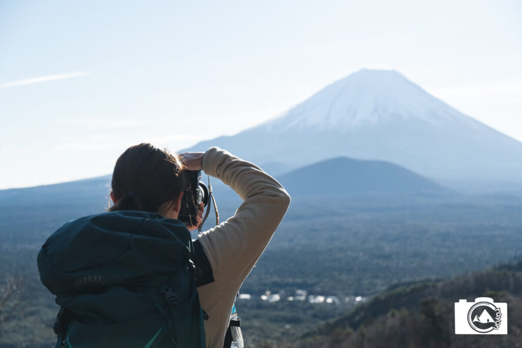 カメラで富士山を撮影している女性