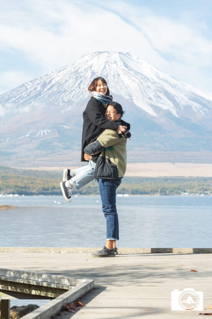 富士山を背景に写真を撮るカップル