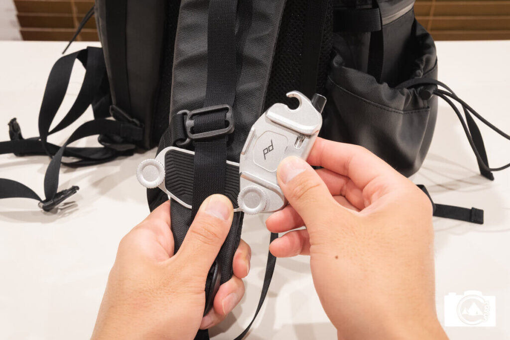 キャプチャーのクリップを開いてリュックのベルトを挟み込むシーン