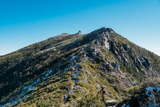 千代ノ吹上の断崖絶壁越しに見える金峰山