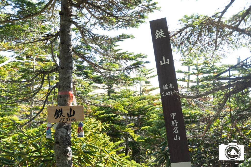 森の中にたたずむ鉄山の標識